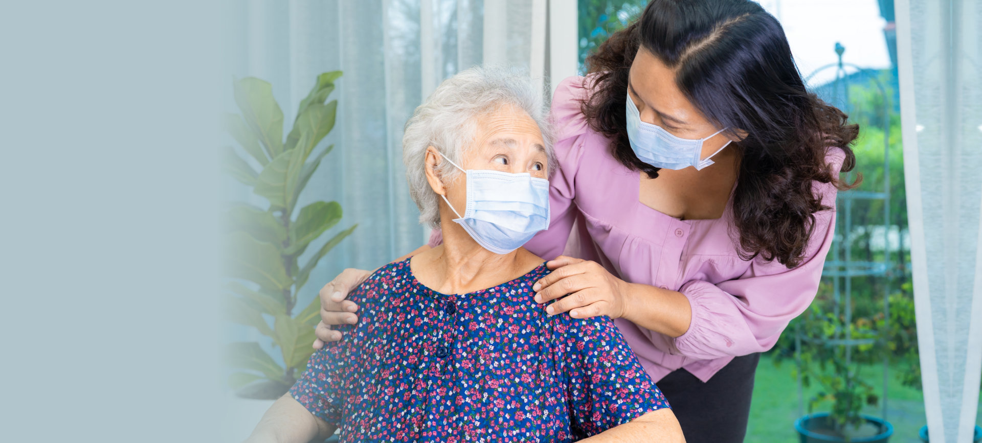 Caregiver help senior woman sitting on wheelchair and wearing a face mask for protect safety infection Covid19 Coronavirus.